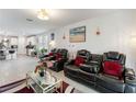 Modern living room with leather reclining chairs, stylish decor, and lots of natural light at 39024 Harlow Rose Dr, Zephyrhills, FL 33540