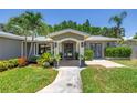 Inviting front entrance showcasing lush landscaping, a modern blue front door, and updated exterior lighting at 4096 38Th S St, St Petersburg, FL 33711
