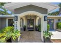 Elegant home entrance with a blue door framed by columns, potted plants, and travertine-tiled walkway at 4096 38Th S St, St Petersburg, FL 33711
