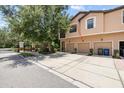 Beautiful townhome featuring three garage doors, complemented by mature trees and lush landscaping at 4103 Via Piedra Cir # 10-101, Sarasota, FL 34233