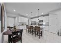 Open kitchen with white cabinets, stainless steel appliances, a center island, and dining area at 5813 Grand Sonata Ave, Lutz, FL 33558
