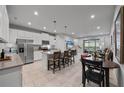 Open kitchen with white cabinets, stainless steel appliances, a center island, and dining area at 5813 Grand Sonata Ave, Lutz, FL 33558