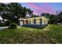 Charming single-story home with a well-manicured lawn and attached garage at dusk at 6401 N Central Ave, Tampa, FL 33604