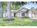 Charming single-Gathering home featuring an attached garage and well-maintained landscaping at 6720 Gilda Dr, Tampa, FL 33625
