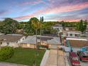 An aerial view of the charming home highlighting the roof with solar panels, driveway, and a lush green yard at 7631 Ironbark Dr, Port Richey, FL 34668