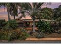 Landscaped home featuring mature palms, a two-car garage, and a covered front porch at 7802 134Th St, Seminole, FL 33776