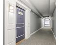 Hallway of condo building with patterned carpet and blue door at 880 Mandalay Ave # C513, Clearwater Beach, FL 33767