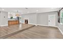 Open-concept living room with wood floors, fireplace, and a view of the kitchen at 9448 Mcintyre Rd, Brooksville, FL 34601