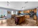 Spacious eat in kitchen with a tile backsplash, stainless steel appliances, and a center island at 10457 Cranston St, Spring Hill, FL 34608