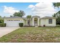 Inviting single-story home features a manicured lawn and attached two-car garage at 1156 Ridgegrove W Dr, Palm Harbor, FL 34683