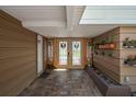 A gorgeous entryway with slate flooring, wooden accents, decorative flower boxes, and glass paneled doors at 1309 Eastfield Dr, Clearwater, FL 33764