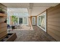 Enclosed, screened in patio with tile flooring, an outdoor dining set, and lots of natural light at 1309 Eastfield Dr, Clearwater, FL 33764
