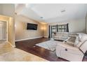 Comfortable living room featuring hardwood floors, neutral walls, a ceiling fan, and sliding door to the lanai at 13167 Roseanna Dr, Spring Hill, FL 34609