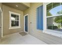 Charming front porch with blue accents and neutral finishes creates a welcoming entrance to this lovely home at 13524 Circa Crossing Dr, Lithia, FL 33547
