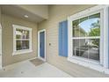 Covered front porch showcasing the blue front door, blue shutters, and two windows at 13524 Circa Crossing Dr, Lithia, FL 33547