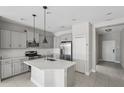 Modern kitchen boasts gray cabinets, stainless steel appliances, a center island, and subway tile backsplash at 13524 Circa Crossing Dr, Lithia, FL 33547