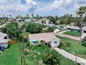 An exterior view shows a quaint home with mature landscaping and a well-maintained lawn in a sunny neighborhood at 1580 Arizona Ave Ne, St Petersburg, FL 33703
