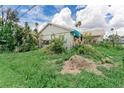 Shows a grassy yard with minimal landscaping and a building with white siding on a sunny day at 1580 Arizona Ave Ne, St Petersburg, FL 33703