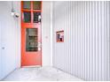 Close-up of a red door with security features and a corrugated metal wall at 2001 E 2Nd Ave # 12, Tampa, FL 33605