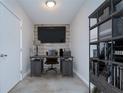 Cozy home office with a rustic desk, shelving, and a wall-mounted TV at 2001 E 2Nd Ave # 12, Tampa, FL 33605