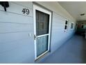 Condo entrance with a dark gray door, unit number 49, and small windows along the exterior wall at 2341 Haitian Dr # 49, Clearwater, FL 33763