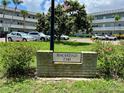 Brick monument sign with the address 'Baghdad 2341' against a background of cars and the condo complex at 2341 Haitian Dr # 49, Clearwater, FL 33763