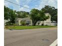 A corner lot with yellow two-story home and mature trees provides a great view at 3516 W Santiago St, Tampa, FL 33629
