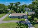 Bright aerial view captures the well-kept lawn, charming curb appeal, and the home's inviting front entrance at 37153 Mcminn Ave, Dade City, FL 33525