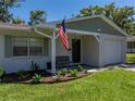 Inviting single-story home with a covered front porch, lush landscaping, and charming curb appeal at 37153 Mcminn Ave, Dade City, FL 33525