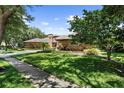 Attractive brick home with a three-car garage sits on a beautifully landscaped lot with mature trees at 3772 Woodridge Pl, Palm Harbor, FL 34684