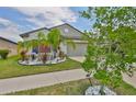Charming house with a palm tree, landscaping, and a spacious driveway at 4485 Eternal Prince Dr, Sun City Center, FL 33573