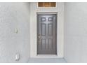 Close-up view of a solid front door with a textured exterior wall finish at 518 Winthrop Dr, Spring Hill, FL 34609