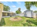 Expansive backyard showcasing a fire pit, shed, screened porch, and pool, ideal for entertaining and enjoying outdoor living at 6012 Flora Ter, Apollo Beach, FL 33572