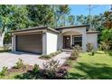 Well-maintained single-story home with a brick driveway, manicured lawn, and an arched entryway at 604 Kinnear Dr, Brooksville, FL 34601