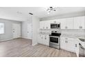 Newly renovated kitchen with stainless steel appliances, white cabinetry, subway tile, and open access to the living space at 7891 67Th N St, Pinellas Park, FL 33781
