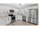 Modern kitchen featuring stainless steel appliances, white cabinets, subway tile backsplash, and sleek black hardware at 7891 67Th N St, Pinellas Park, FL 33781