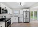 Modern kitchen featuring stainless steel appliances, white cabinets, subway tile backsplash, and sleek black hardware at 7891 67Th N St, Pinellas Park, FL 33781