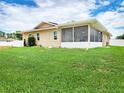 Backyard with a spacious screened in porch, green grass, and well maintained siding at 8110 Damara Dr, New Port Richey, FL 34653