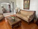 Cozy living room featuring classic furniture, hardwood floors, and a view into the dining area at 9220 Hidden Water Cir, Riverview, FL 33578