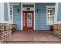 Close up of the front entrance shows a bright red door and well-maintained brick porch at 10015 Brompton Dr, Tampa, FL 33626