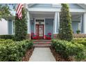 Inviting front porch with red chairs and well-maintained landscaping offers a cozy curb appeal at 10015 Brompton Dr, Tampa, FL 33626