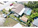 Aerial view of the backyard featuring an enclosed pool, a shed, and a boat on a trailer secured behind a fence at 11996 117Th St, Seminole, FL 33778