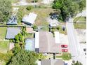 Aerial view showcases property including pool, additional building, driveway, and surrounding foliage at 12037 1/2 Murray Ave, Seminole, FL 33778