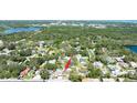 Drone shot showcases the property with surrounding neighborhood, water and lush trees at 12037 1/2 Murray Ave, Seminole, FL 33778