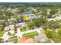 Aerial view of a neighborhood featuring mature trees and a nearby pond, with an arrow pointing to subject property at 12092 97Th Ave, Seminole, FL 33772
