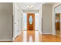 Bright foyer with a decorative front door, hardwood flooring, and a modern chandelier at 13883 Jamaica Dr, Seminole, FL 33776