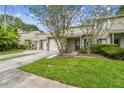 Inviting townhouse featuring lush green grass and mature landscaping, enhancing curb appeal at 1508 Adams E Cir, Largo, FL 33771