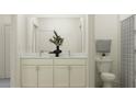 Bright bathroom with white cabinetry, double sinks, marble countertops, and decorative plant accents at 18137 Serene Lake Loop, Lutz, FL 33548