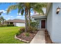 Charming front entrance featuring a walkway, garden bed and a pop of color with flowers at 1821 Hawks View Dr, Ruskin, FL 33570