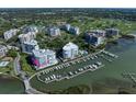 Aerial view showcasing the condos, boat docks, and golf course with a marked unit location at 2 Seaside Ln # 203, Belleair, FL 33756